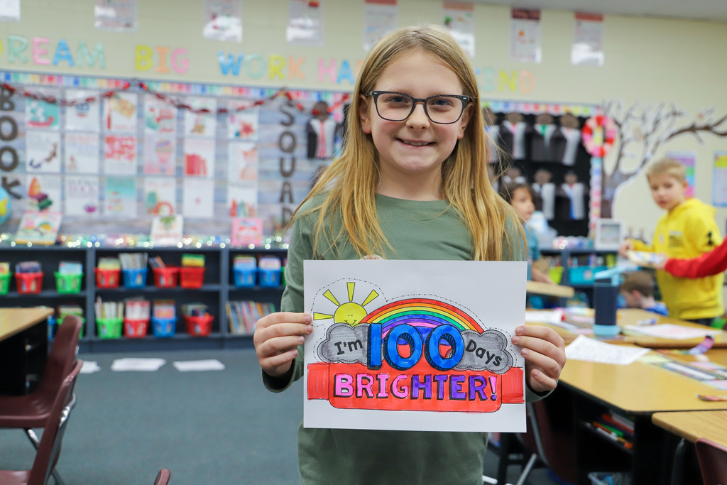 student holding 100 day sign