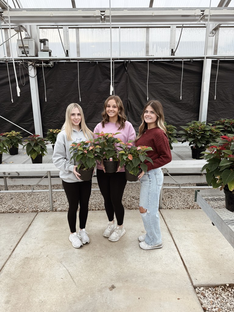 students holding poinsettia