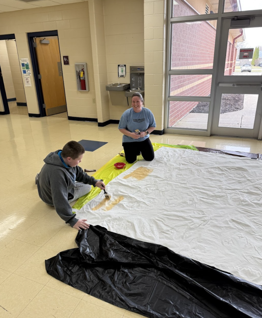 Student and parent painting a set design for Beauty and the Beast show 1