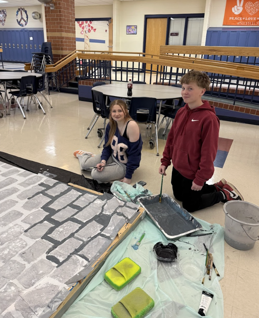 Students painting a set design for Beauty and the Beast show 2
