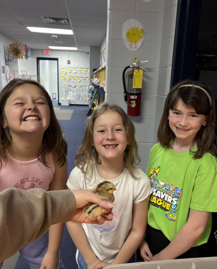 Students posing with chick