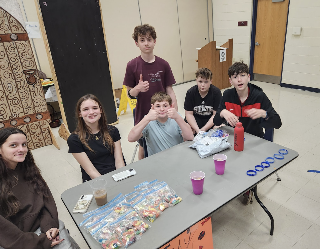 Group of students during entrepreneurship sale selling candy and Brookwood bracelets