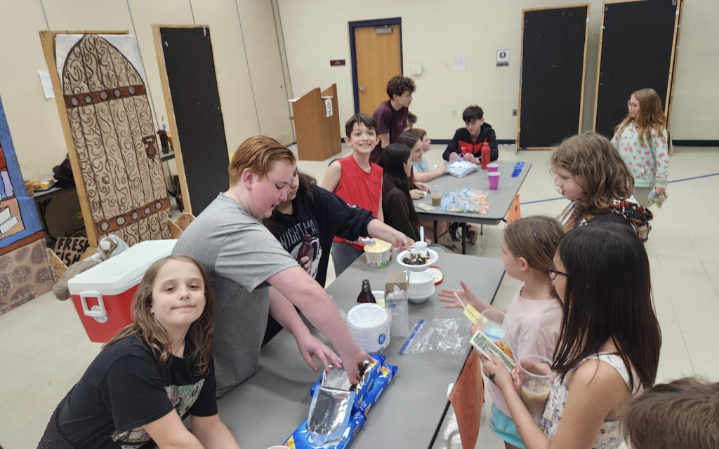 Group of students during entrepreneurship sale selling to customers - ice cream sunde