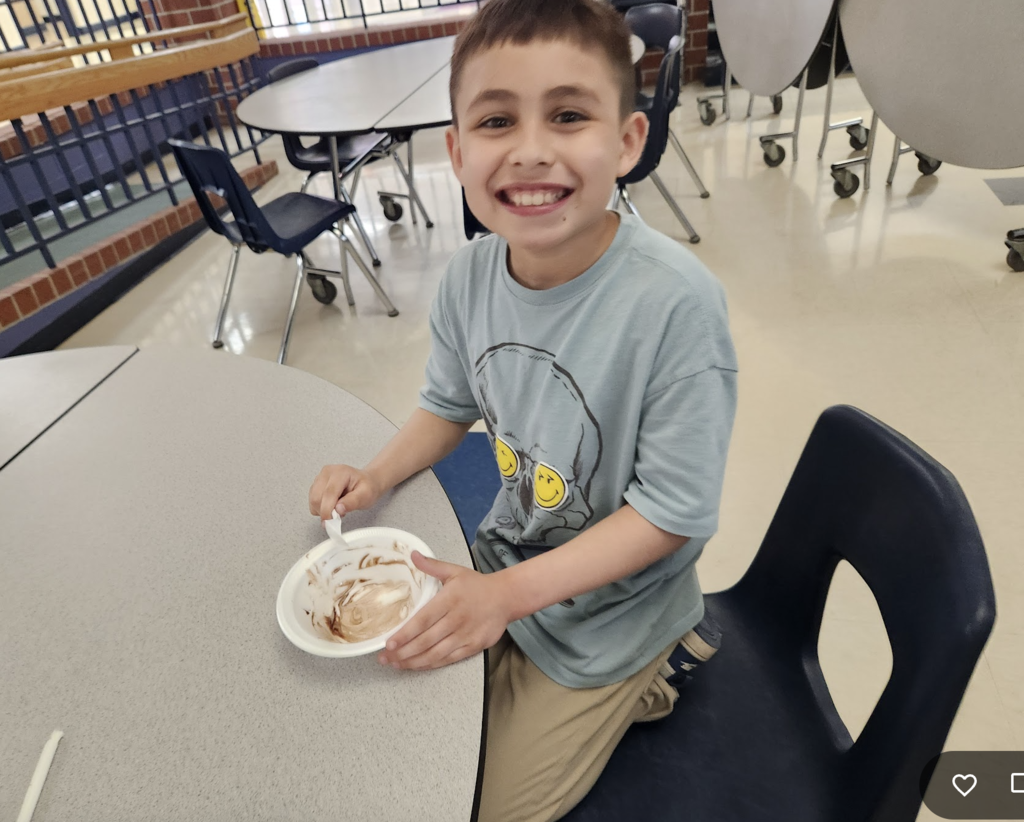 Student enjoying their ice cream sunday purchase from entrepreneurship sale