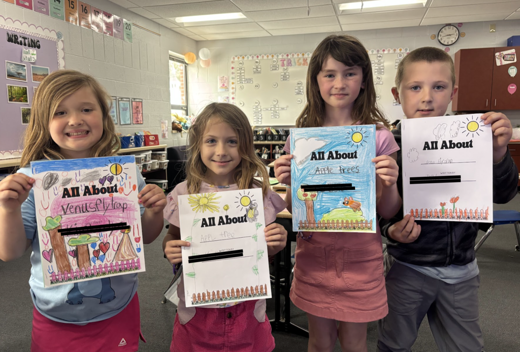 Students showing off their All About Plants books 2