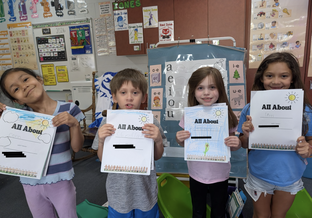 Students showing off their All About Plants books