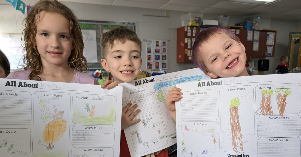 Students showing off their All About Plants worksheet