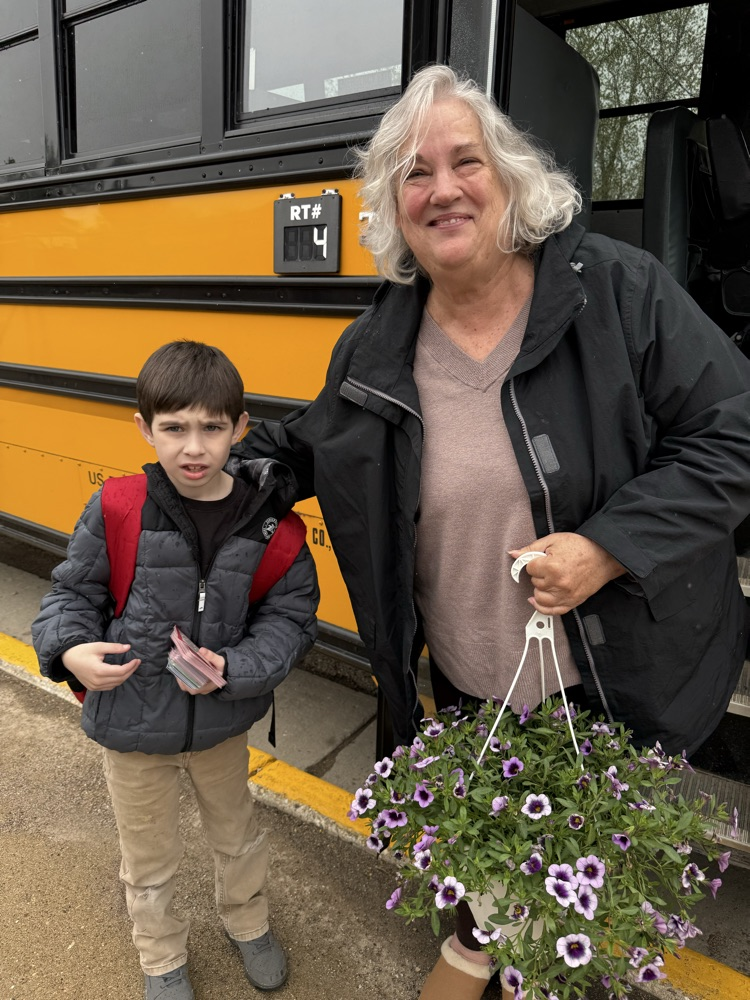 bus driver with student presenting flowers as a gift