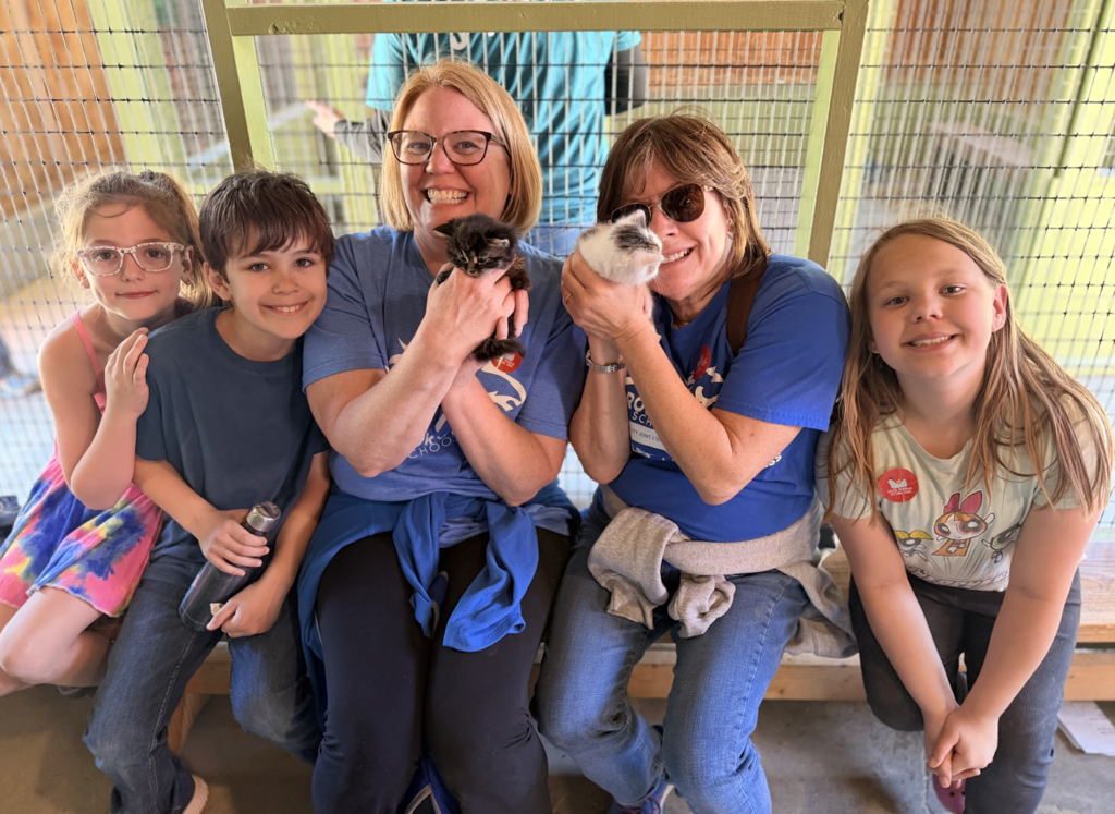 students and staff in the kitten barn