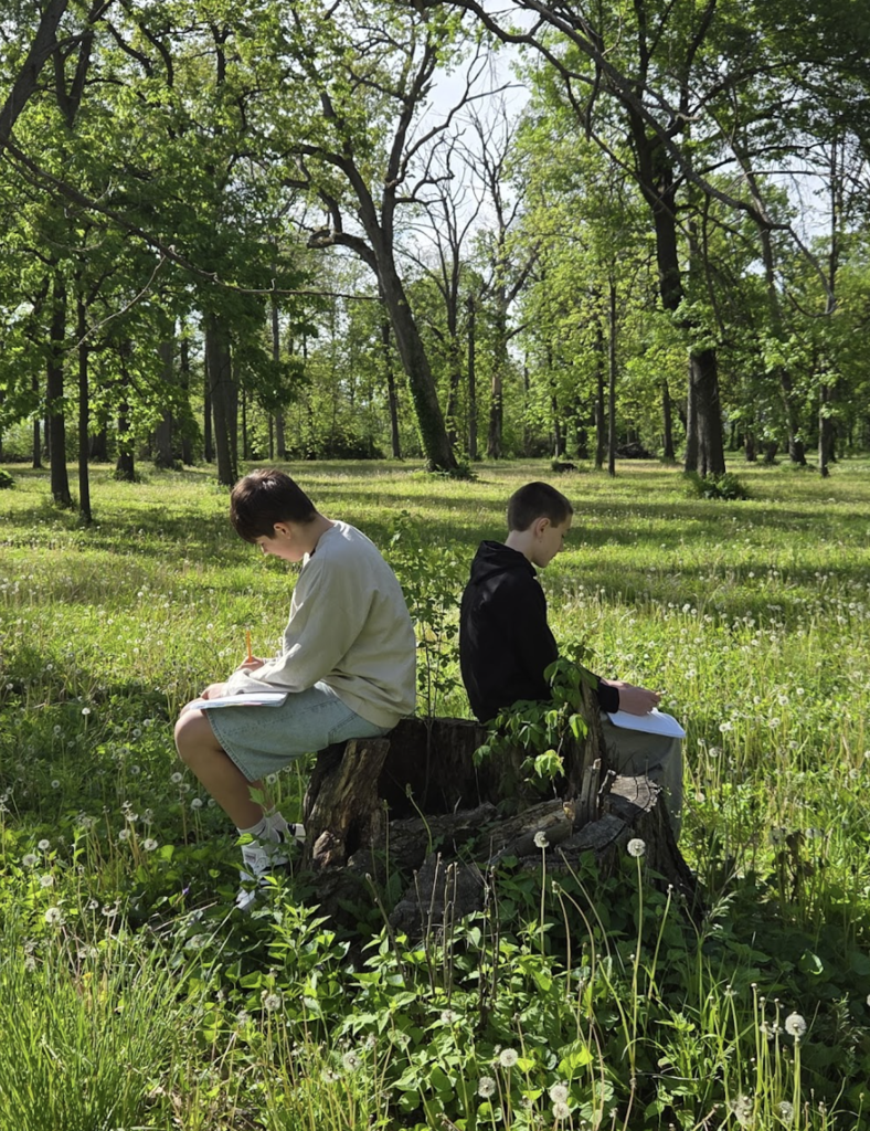 7th grade ELA students took advantage of the beautiful weather today by bringing their creative writing outdoors. As part of their current creative writing unit, students focused on developing strong setting and imagery by paying close attention to the world around them, what they could see, hear, smell, and feel in nature. Using the outdoors as inspiration, students worked to create vivid descriptions that help bring their writing to life. 5
