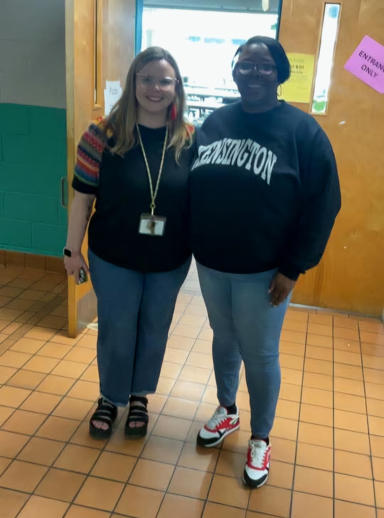 2 staff members standing in hallway