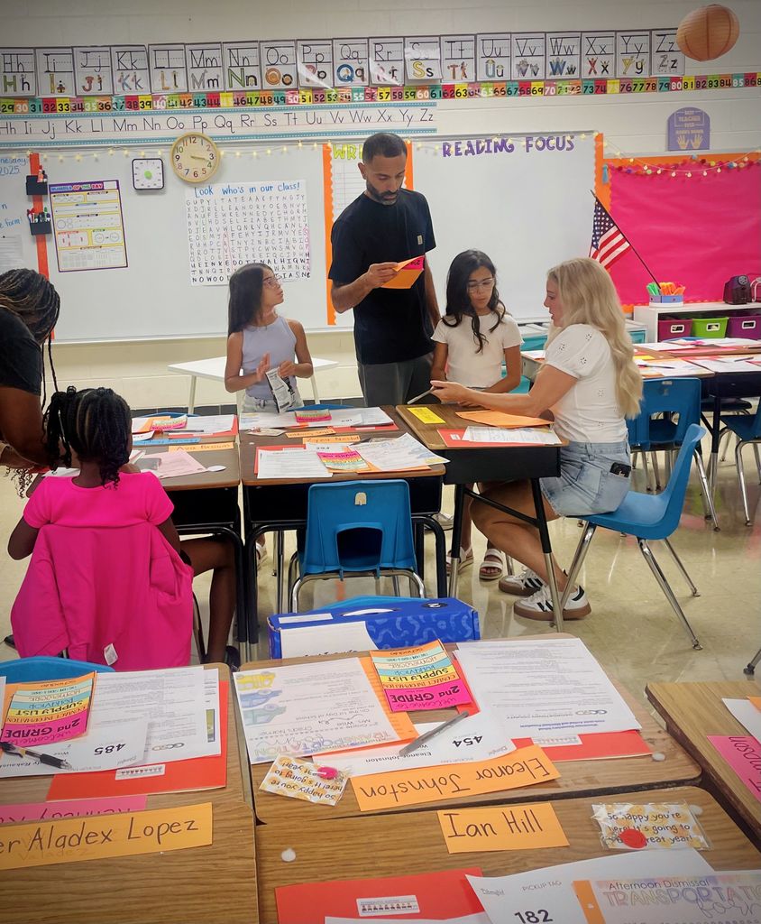 Parents and their students sitting at desks in a classroom