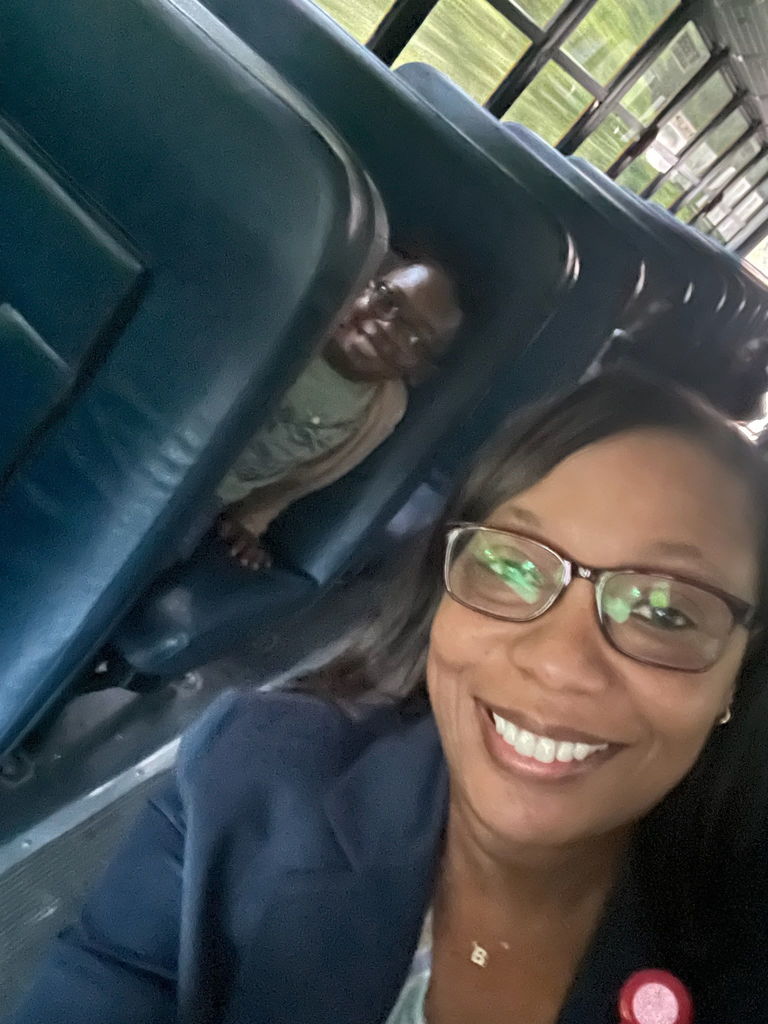 Dr. Giles (front) riding bus to school with students