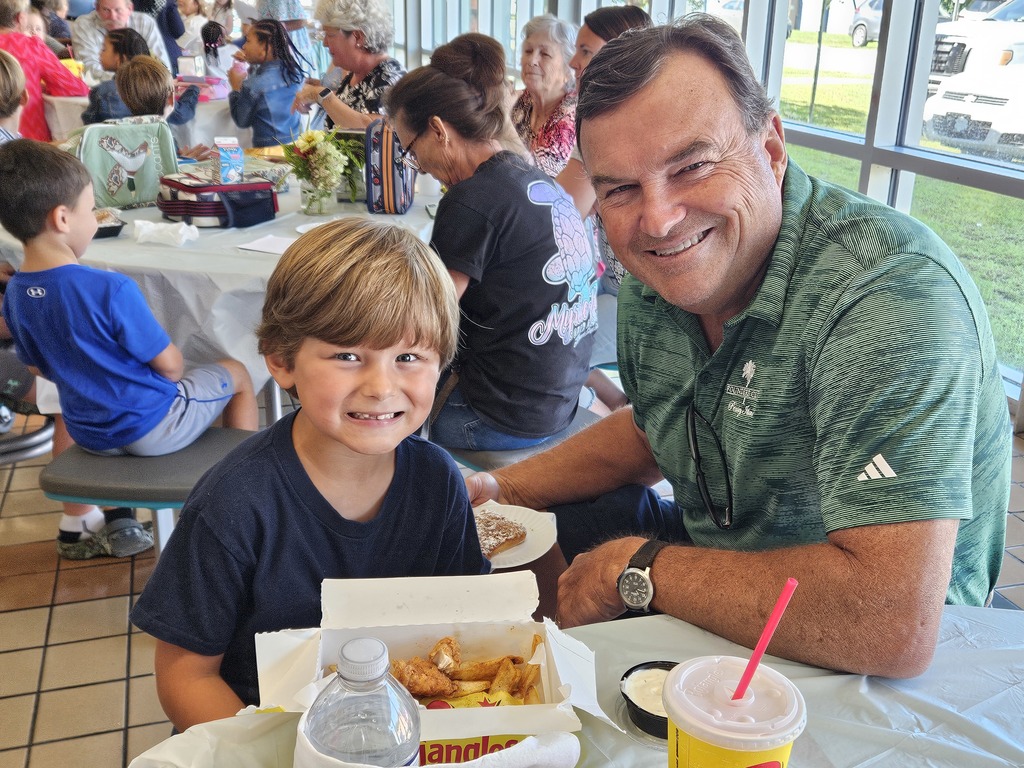 Grandfather with grandson in cafeteria