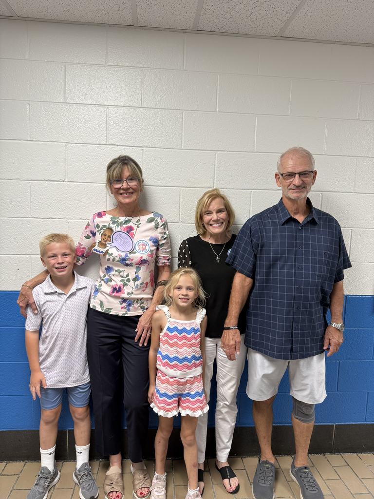 Three Caucasian Adults standing with two caucasian children a boy and a girl