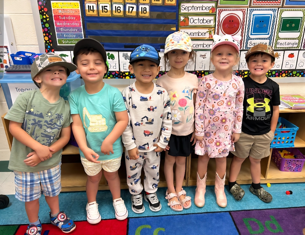 Students standing and wearing hats.