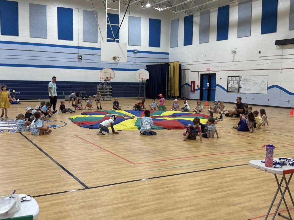 Students sitting in a circle in the gym.
