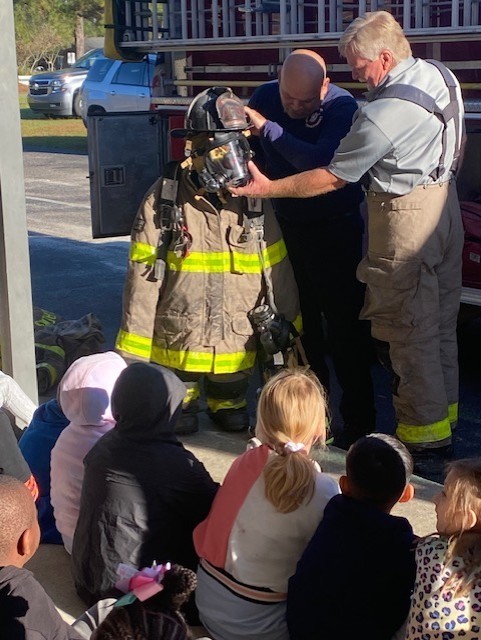 firefighters showing student their equipment