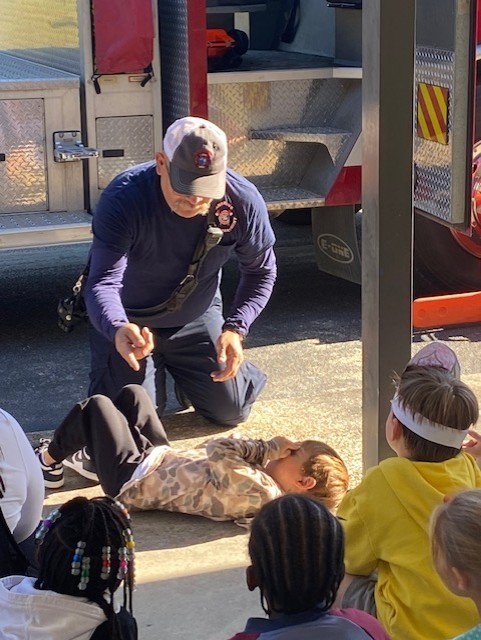 firefighters showing students how to stop drop and roll