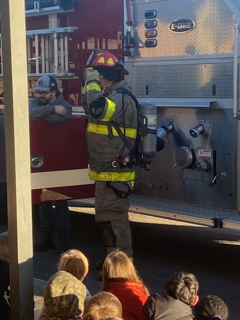 firefighters showing student their equipment