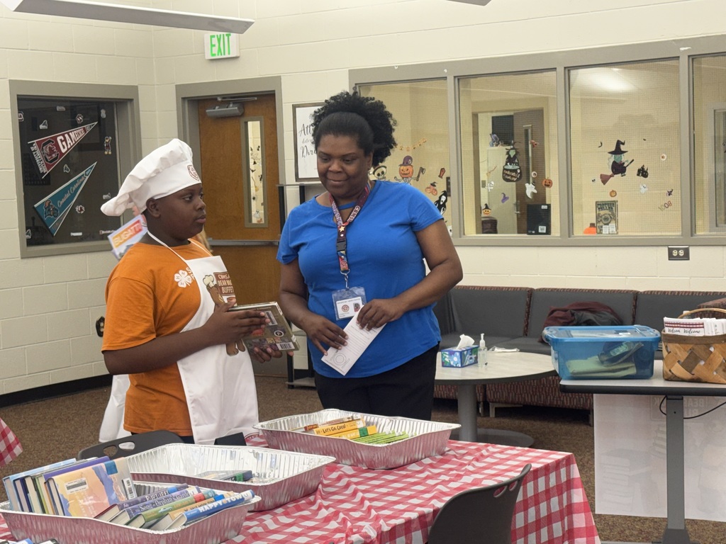 Student helper showing his book choice to Ms. Fulton!