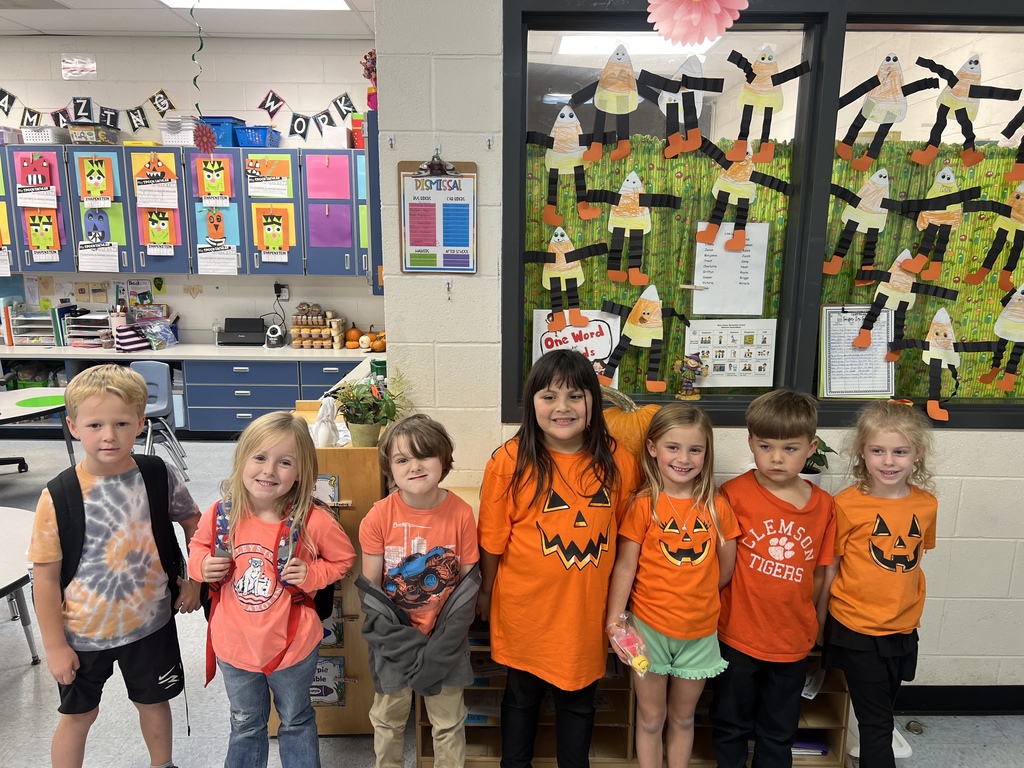 Boys & Girls standing together, most wearing the color orange. 