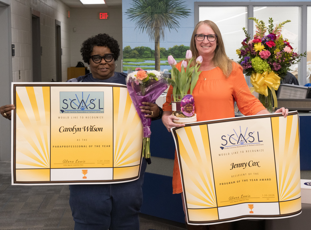Wilson (Left) and Cox (right) holding up  recognition banners.