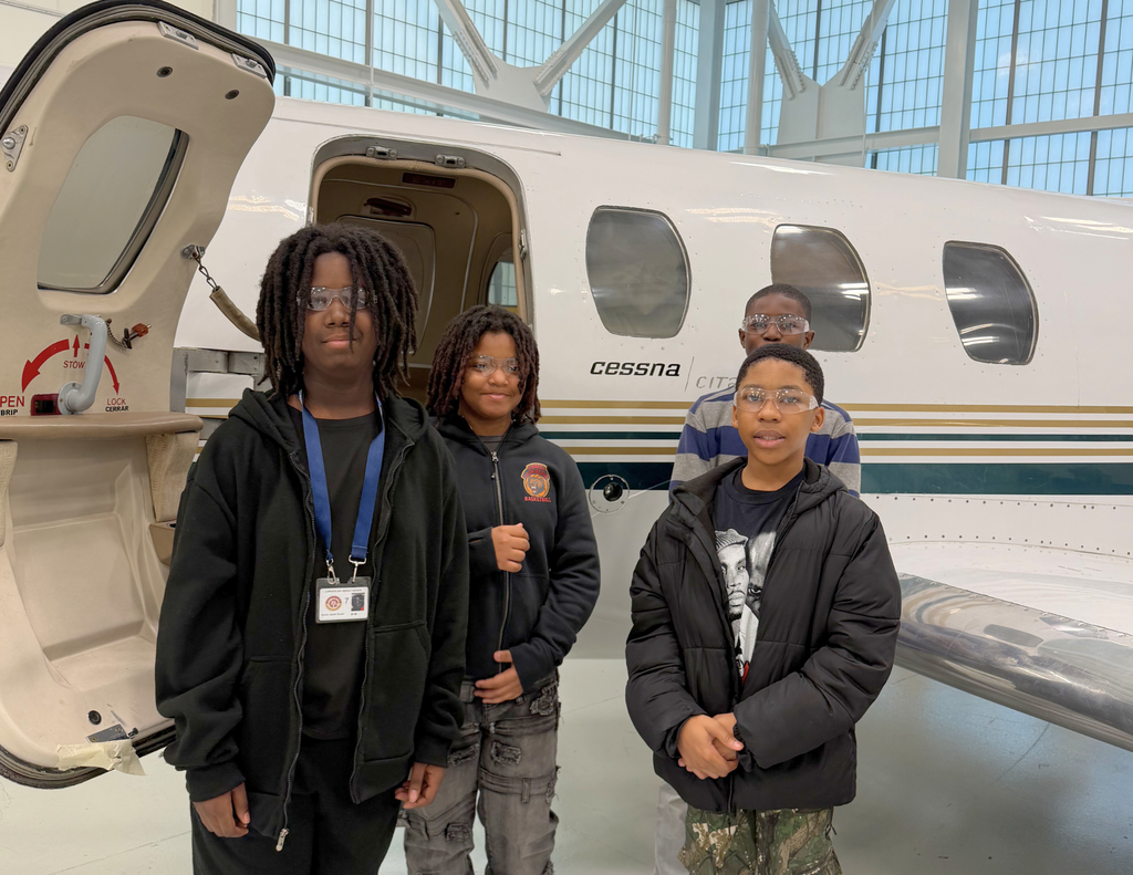 Four boys standing in front of a plane they were interested in.
