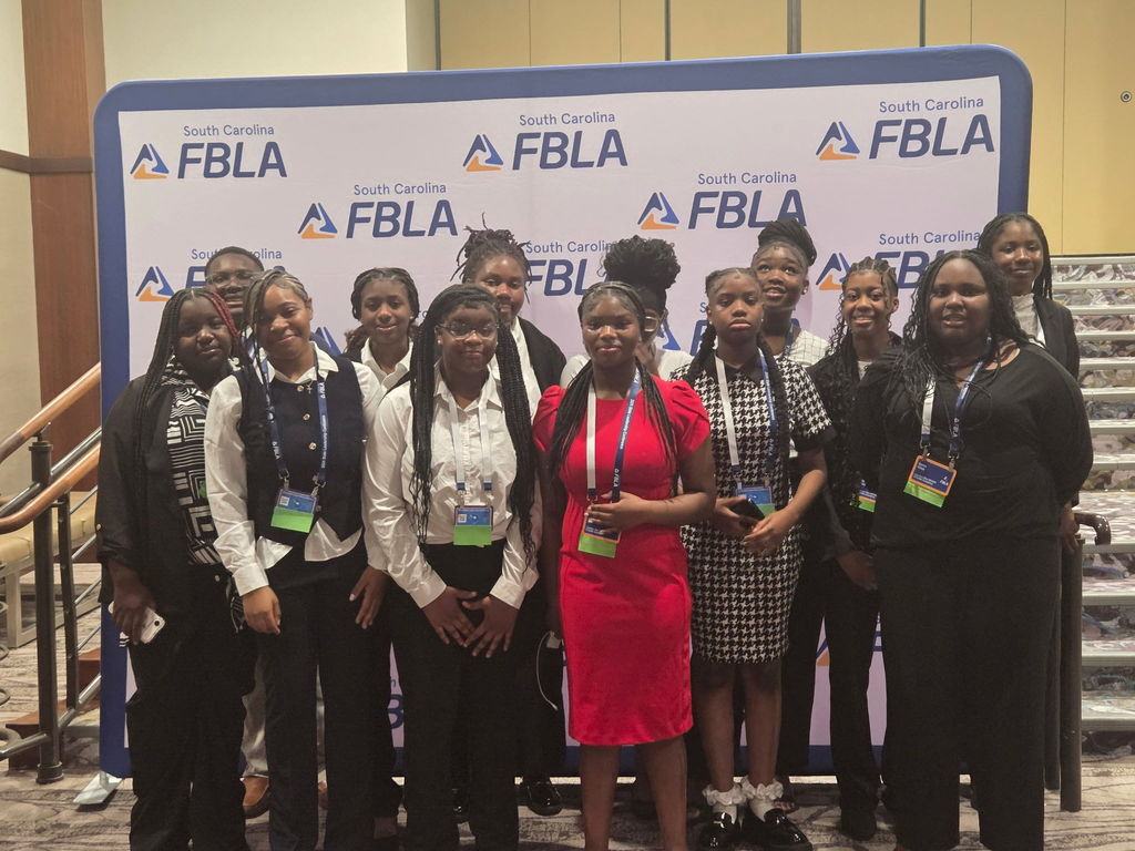 Our Middle School FBLA members posing in front of the FBLA banner.