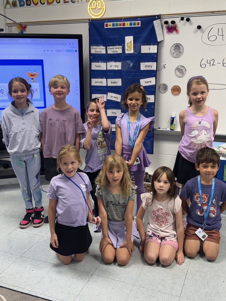Group of elementary students in a classroom wearing purple for Purple Up Day.