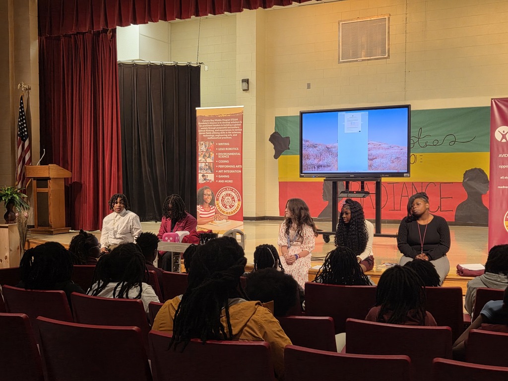 Student Avid leaders sitting on stage in front of 5th graders.