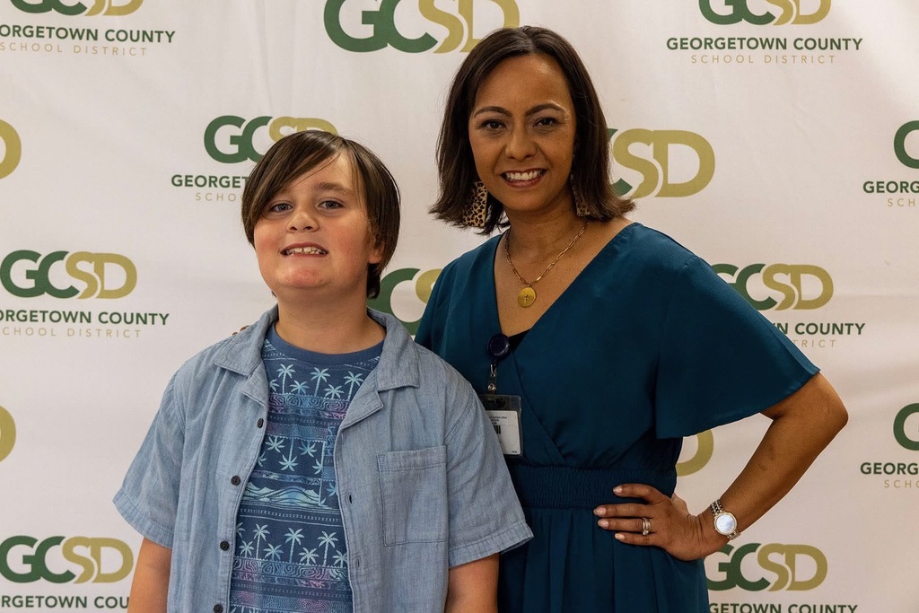 Student posing with a school principal during an award recognition ceremony.