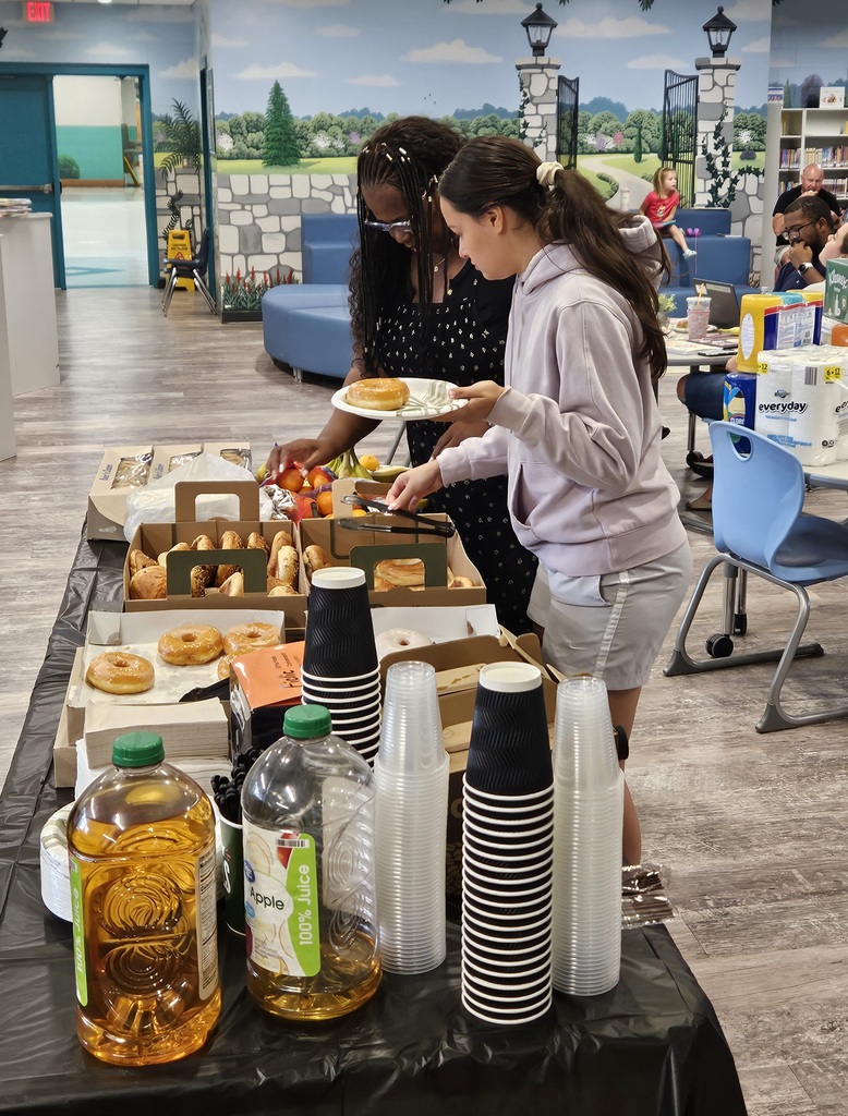 2 staff members fixing their breakfast plates at a table