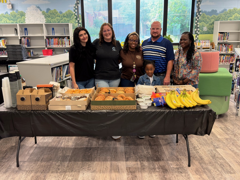 Karate World staff with KES staff standing behind a table set up for breakfast