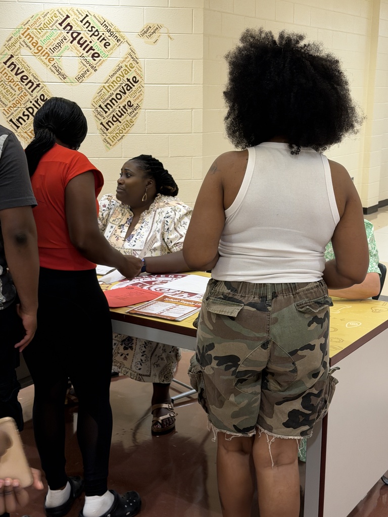 Parents and guardians picking up student schedules from Mrs. Tucker and Mrs. Smith.