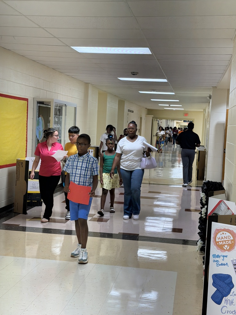 Families and students exploring Club posters in the hall