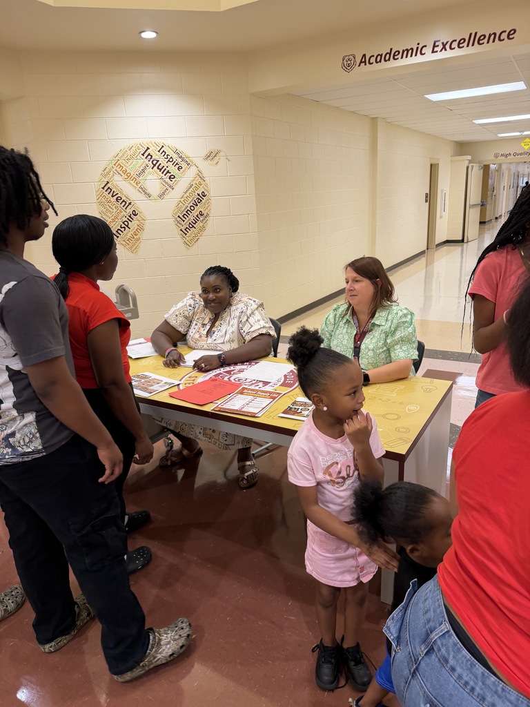 Parents and guardians picking up student schedules from Mrs. Tucker and Mrs. Smith.