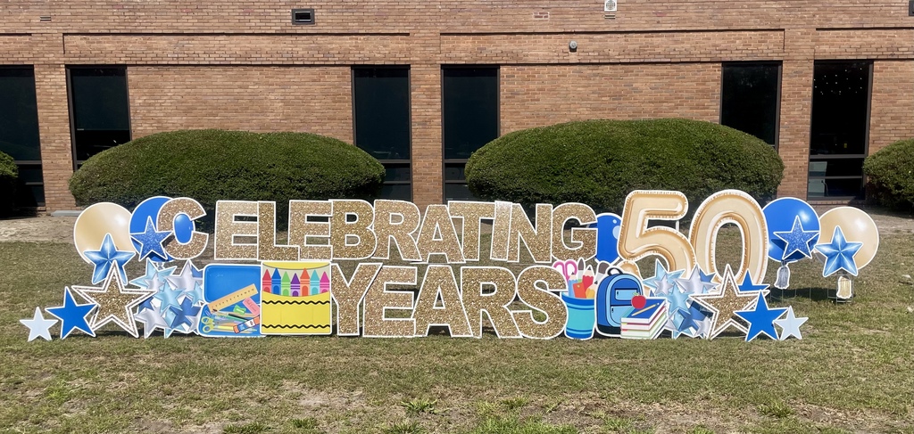 Outdoor display celebrating 50 years with stars and school supplies.