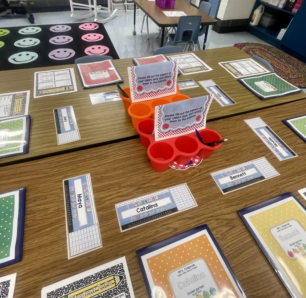 Classroom tables prepared with student folders and forms.
