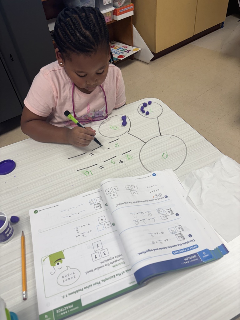 First grader using playdoh to solve addition problems