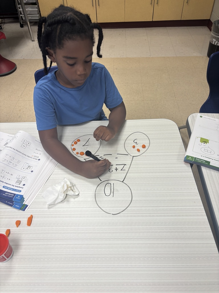 First grader using playdoh to solve addition problems