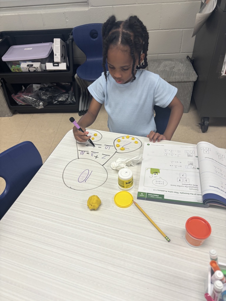 First grader using playdoh to solve addition problems