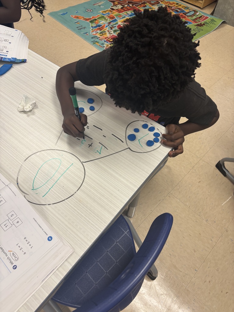 First grader using playdoh to solve addition problems
