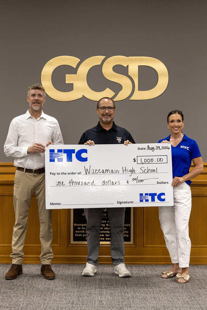 Todd Rodenbeck,  WHS Golf Coach, accepts the donation from HTC.