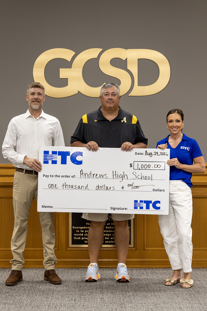 Scott Durham, AHS Athletic Director, accepts the donation from HTC.
