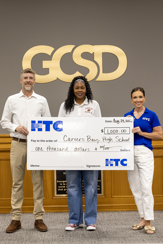 Nicole Tucker-Young, Principal of CBECCHS, accepts the donation from HTC.