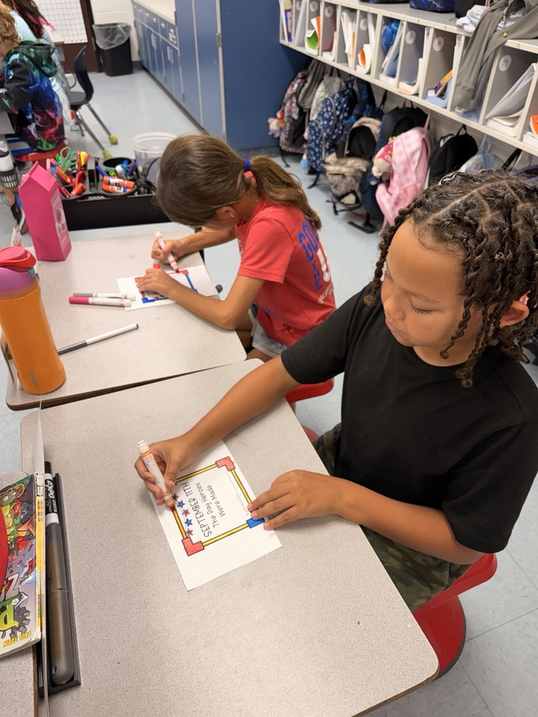 Two Waccamaw Elementary students work on a Patriot Day classroom activity. A student colors a page titled “September 11th: The Day Heroes Were Made.”