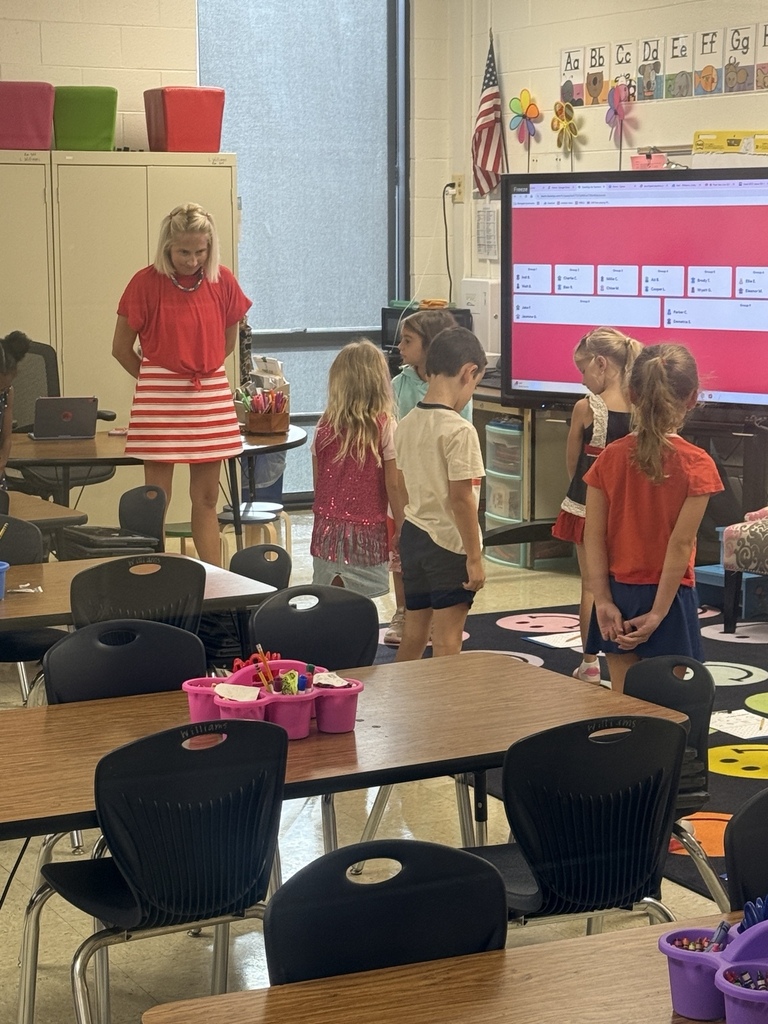Waccamaw Elementary students and their teacher stand quietly together in their classroom while observing a moment of silence in recognition of Patriot Day.