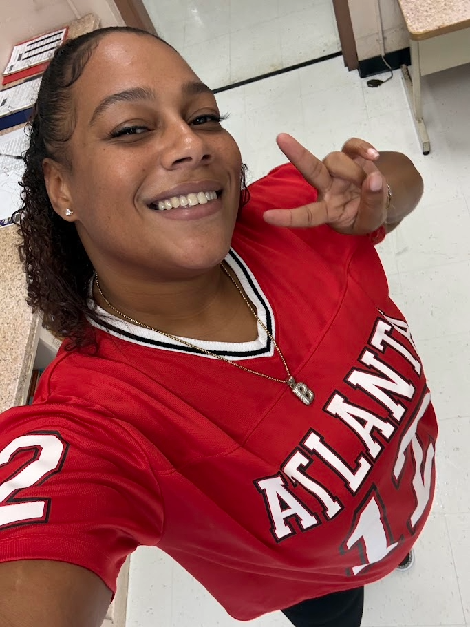 Smiling student in red Atlanta sports jersey number 12 takes selfie indoors during Georgetown County Adult Education event