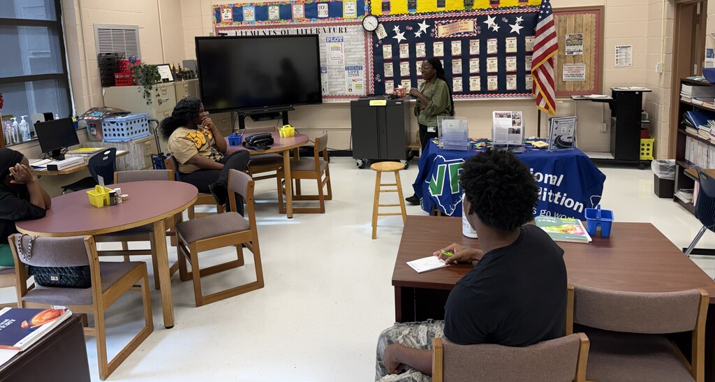 Students seated around tables in a classroom engaging with the speaker from Vocational Rehabilitation Services.